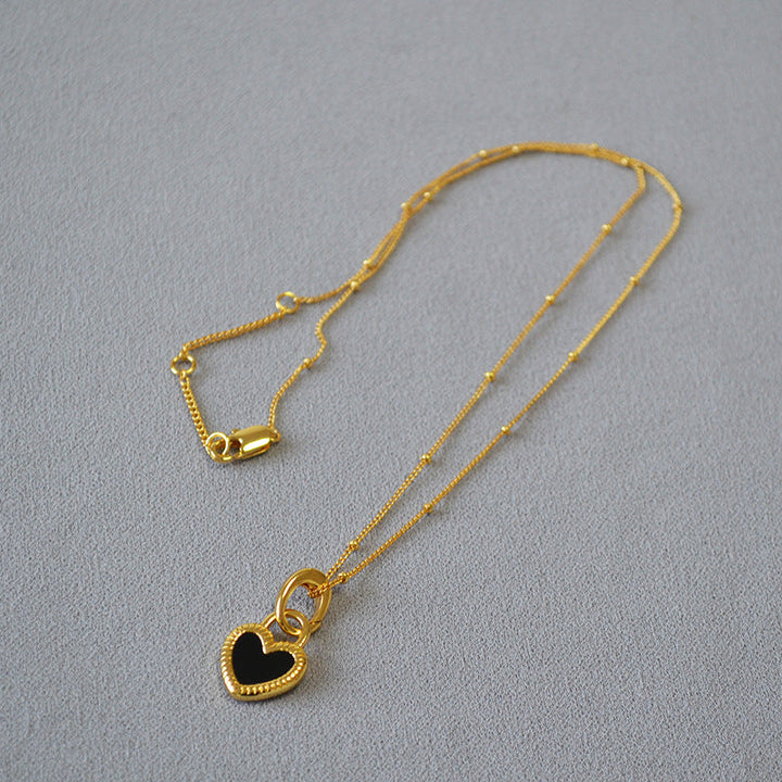 Collar con colgante de corazón blanco y negro en oro
