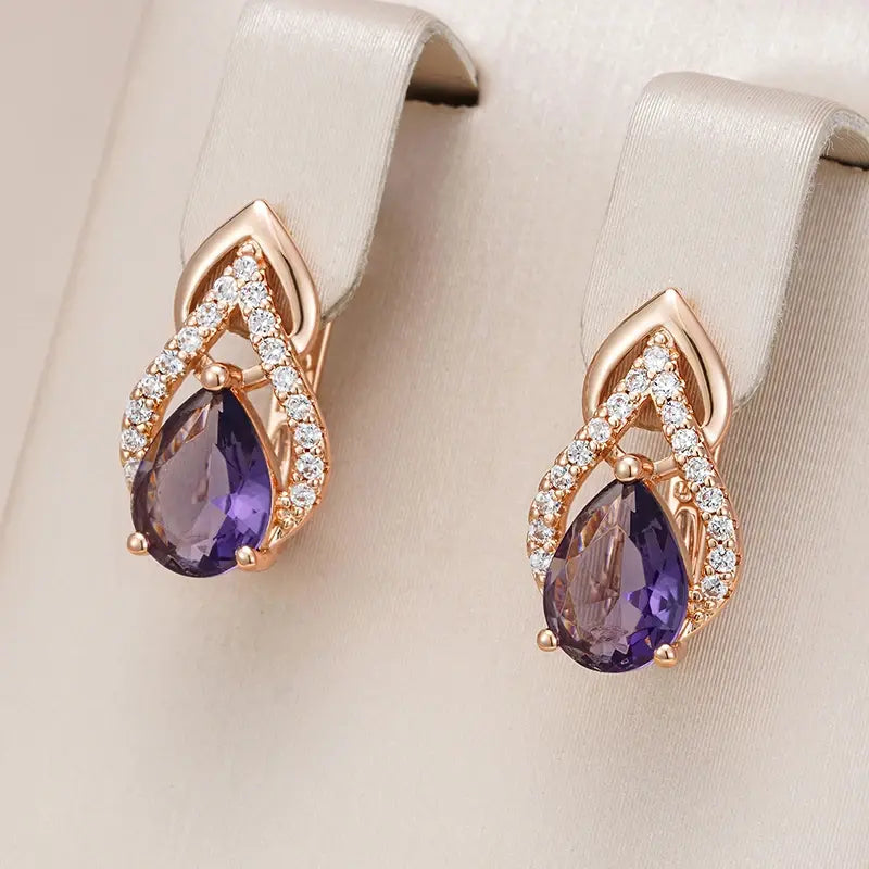 Elegantes pendientes dorados con cristal morado colgante