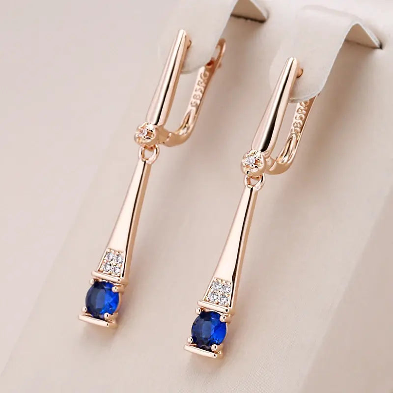 Pendientes dorados con colgante de cristal azul