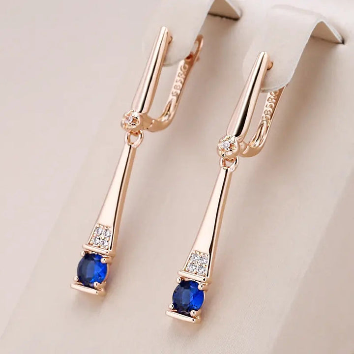 Pendientes dorados con colgante de cristal azul