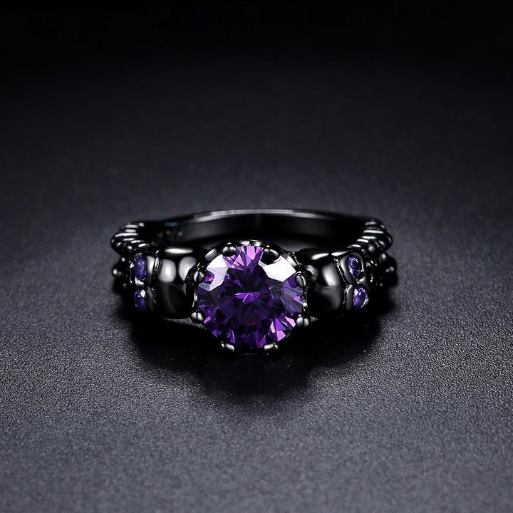 Anillo vintage redondo negro con una piedra preciosa morada